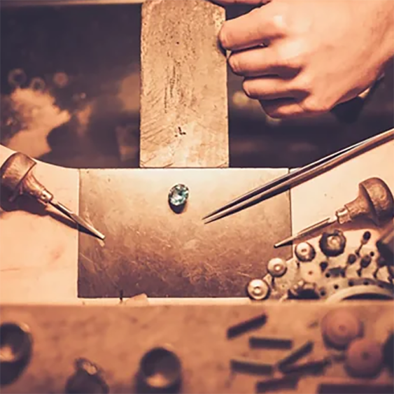 Goldsmith workbench with tools and jewelry components laid out