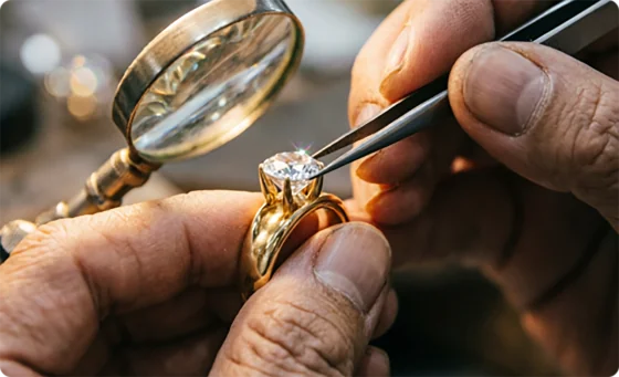 Master setter placing stone in pendant