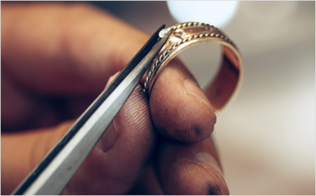 Craftsman setting a stone into a custom jewelry piece