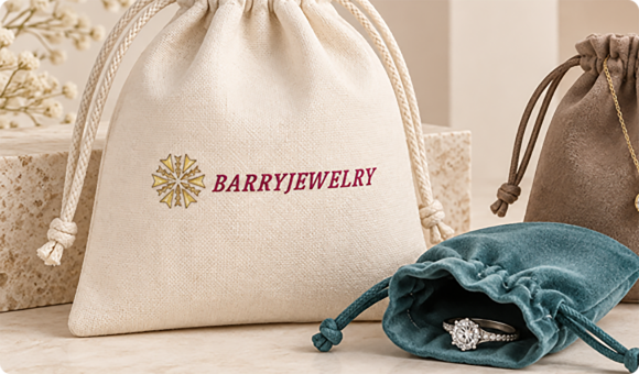 Cotton and velvet jewelry pouches with printed logo beside gift packaging on a table