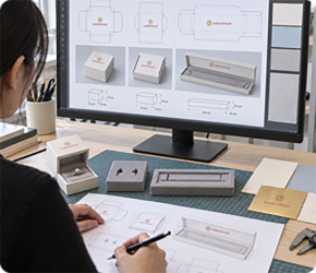 Packaging specialist reviewing jewelry packaging details on a computer at a desk