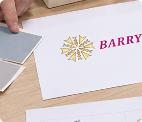 Printed logo sheet laid out on a workbench with a pencil for packaging artwork review