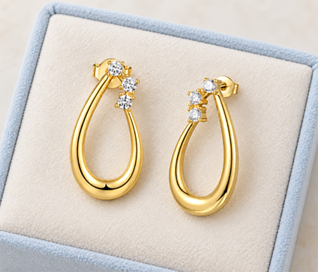 Private label gold drop earrings with stone-set details presented in a box