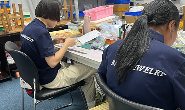 Factory team reviewing packed jewelry orders before shipment release
