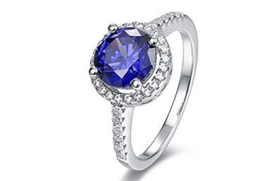 Ring with a round blue center stone held by a distinctive prong detail