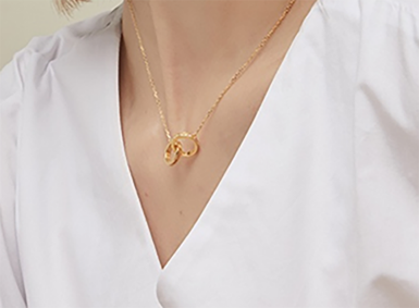 Model wearing a delicate gold pendant necklace with a refined presentation