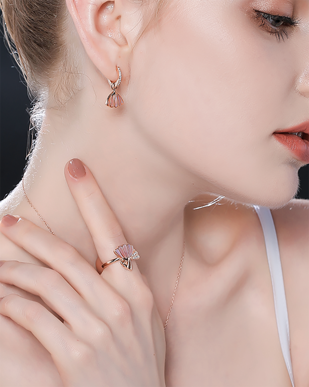 Model wearing a fine earring and ring with soft studio lighting