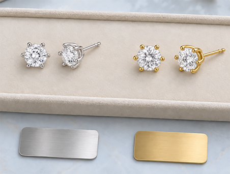 Moissanite stud earrings in silver and gold settings beside brushed metal finish plates